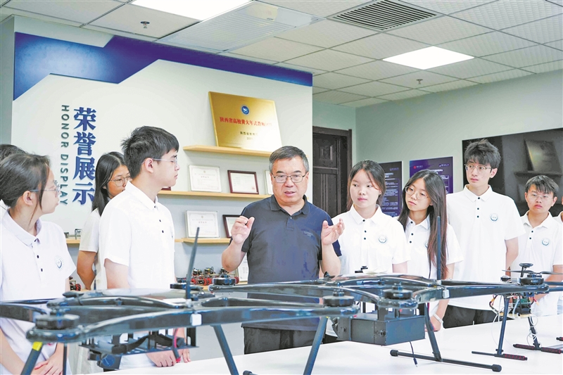 西安电子科技大学教授马建峰(中)与学生交流。 受访单位供图